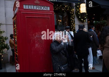 Touristes festifs en force prenant des selfies et des photos d'expositions de Noël le long de Old Bond Street au cœur de Mayfair à Londres, le 20 décembre 2023. Banque D'Images