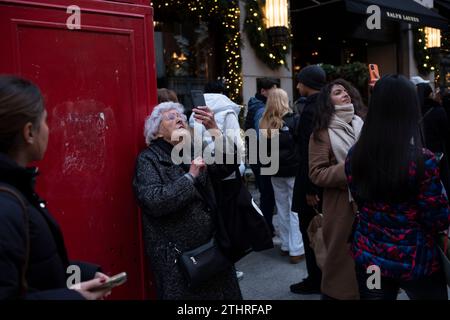 Touristes festifs en force prenant des selfies et des photos d'expositions de Noël le long de Old Bond Street au cœur de Mayfair à Londres, le 20 décembre 2023. Banque D'Images