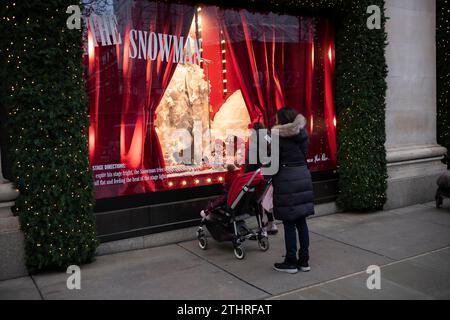 Touristes festifs regardant les vitrines de Noël devant le grand magasin Selfridges dans le West End de Londres, le 20 décembre 2023. Banque D'Images