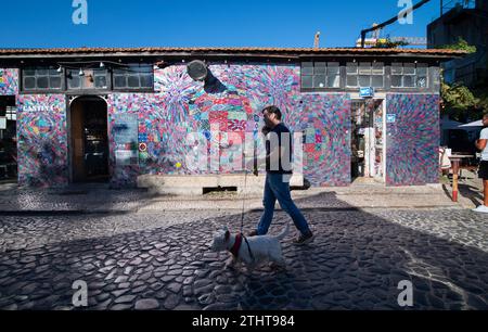 Usine LX, Lisbonne, Portugal. Street art à l'extérieur de la Cantina LX. Un homme promène son chien devant l'oxymore Tiling de l'artiste portugaise, abstraite géométrique et cinétique Margarida Sardinha. Banque D'Images