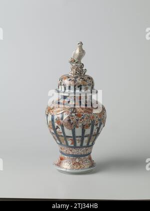 Pot balustre couvert avec des figures dans un intérieur derrière le cadre, arbres prunus et rouleaux floraux, anonyme, c. 1650 - c. 1699 pot à couvercle en porcelaine en forme de balus avec une base d'étalement, peint en bleu glacé sous-jacent et sur le glaçage rouge, noir et or. Sur le mur deux fois deux personnes assises dans un intérieur derrière le travail de calandre modélisé et peint. Cette grille est décorée avec des arbres prunus modelés et décorés et des pneus avec des vignes fleuries. Sous la grille travailler une bande avec des vignes fleuries. Autour du pied un lien avec lotus Drinks. Sur le cou trois cartouches avec des vignes de lotus. Le couvercle avec le même déc Banque D'Images