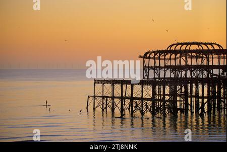 Pédalo silhoueté sur la jetée ouest abandonnée au coucher du soleil, Brighton, Angleterre.Construit en 1866 et fermé en 1975, le quai est toujours classé de catégorie I et un site bien connu. Banque D'Images