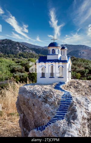 Petite église bleue et blanche sur un rocher près du village de zia sur l'île de kos, grèce. Banque D'Images