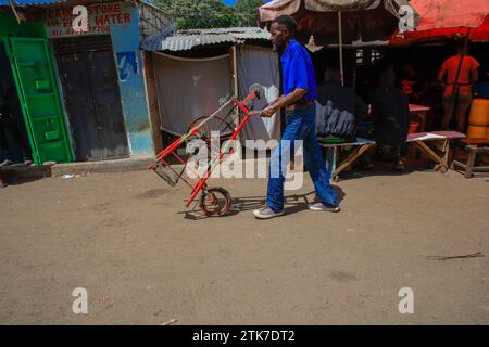 Un coutelier conduit sa machine dans les rues du bidonville de Kibera, Nairobi. Une vue à travers la vie quotidienne à Kibera actuellement le plus grand bidonville d'Afrique et Banque D'Images