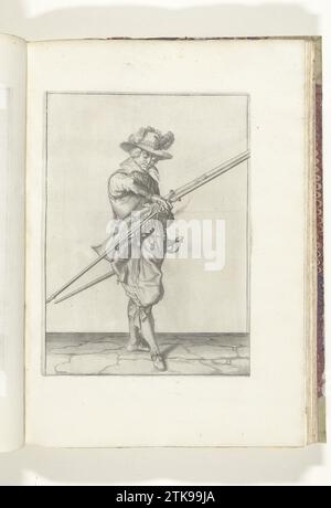Soldat avec un mousquet qui transfère sa mèche de sa main droite à sa main gauche (n° 15), ca. 1600, 1608 Un soldat, à droite, qui tient un mousquet (un certain type d'arme à feu) et une furmeret (fourche de mousquet) avec sa main gauche (n° 15), ca. 1600. Il transmet la mèche brûlante de sa main droite à sa main gauche. Planche 15 dans les instructions pour la manipulation du mousquet : Corte Initiation sur l'image Figuerlicke, tant agaet le droit Ghebruyck van Musquet. Partie des illustrations dans : J. de Gheyn, Weapon Handele of Roers Musquetten and Spiessen, Amsterdam, 1608. Prix de guerre vers 1600. Imprimeur : NOR Banque D'Images