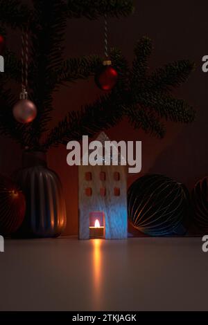 Bougie allumée et décorations de Noël en bois avec des branches de sapin sur fond sombre. Carte de voeux de Noël ou de nouvel an. Banque D'Images