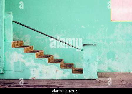 Couleur et texture d'une entrée de magasin bahamien, Un ensemble d'escaliers menant à un mur vert Banque D'Images