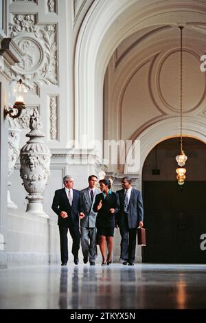 Un groupe de cadres de race mixte marchant ensemble dans le couloir dans un bâtiment orné Banque D'Images