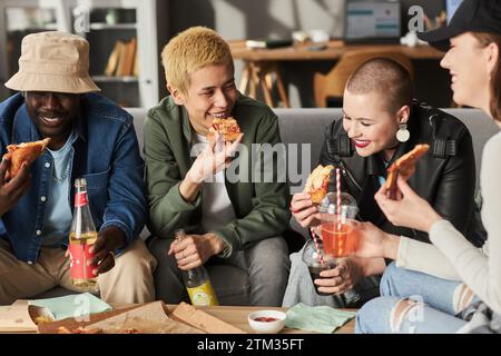 Heureux jeunes adultes appréciant Pizza Banque D'Images