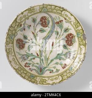 Plat avec une plante à fleurs stylisée, anonyme, c. 1575 - c. 1590 Discount of quartz fritry décoré d'une plante à fleurs stylisée en vert, bleu, jaune, brun et rouge sur blanc sous un vernis transparent plomb-alcali-laze. Un motif nuage ou boucle sur le bord. Iznik. Faïence Iznik. Peinture émaillée / vitrification Discount of quartz fritry décoré d'une plante à fleurs stylisée en vert, bleu, jaune, brun et rouge sur blanc sous laze transparente plomb-alcali. Un motif nuage ou boucle sur le bord. Iznik. Faïence Iznik. peinture de glaçage / vitrification Banque D'Images