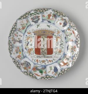 Plaque portant les armoiries d'Amsterdam, anonyme, c. 1710 soucoupe en porcelaine avec paroi nervurée et bord festonné, peinte en bleu glacé et sur le bleu glacé, rouge, vert, jaune, noir et or. Sur l'appartement dans un médaillon l'arme couronnée d'Amsterdam avec l'inscription 'Amsteldam', autour de l'arme des branches de fleurs, deux papillons et deux oiseaux. Le mur est divisé en douze sujets pétales avec alternativement un vase à fleurs (aster, prunus, pivoine, lotus, orchidée, chrysanthème) et une personne dans un paysage ; entre les compartiments de servetwork. Le dos avec deux branches de fleurs. Certains Banque D'Images