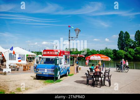 Thionville, France - Jun 10, 2016 : une camionnette unique en verre avec une terrasse installée au bord de la Moselle à Thionville, avec des gens r Banque D'Images