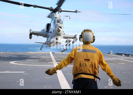 Le Mineman de 3rd Class Ethan Crawford, originaire d'Edmore, Michigan, affecté à bord du navire de combat littoral USS Cincinnati (LCS 20), dirige un hélicoptère AH-1Z Cobra attaché au Marine Light Attack Helicopter Squadron (HMLA) 367, Marine Aircraft Group 39, 3rd Marine Aircraft Wing, alors qu’il atterrit sur le pont d’envol du navire à l’appui de l’exercice Steel Knight 23.2, 29 novembre 2023. Steel Knight est un exercice en trois phases conçu pour former la I Marine Expeditionary Force à la planification, au déploiement et au commandement et au contrôle d'une force conjointe contre une force de combat adversaire pair ou quasi pair an Banque D'Images