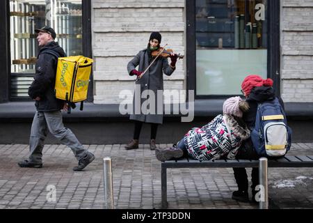 Kiev, Ukraine. 20 décembre 2023. Un musicien de rue joue du violon tandis qu'une personne passe par un raid aérien dans le centre de Kiev. (Photo Oleksii Chumachenko/SOPA Images/Sipa USA) crédit : SIPA USA/Alamy Live News Banque D'Images