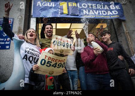 Madrid, Espagne. 22 décembre 2022. Un groupe de personnes célèbrent le premier prix de loterie avec des pancartes et les numéros gagnants. Les gestionnaires du bureau national de loterie 'El Elefante azul', situé dans la rue Arenal de Madrid, célèbrent le premier prix 'jackpot' dans la loterie de Noël obtenu dans leur administration de loterie. La loterie de Noël est célébrée en Espagne chaque 22 décembre. (Photo de David Canales/SOPA Images/Sipa USA) crédit : SIPA USA/Alamy Live News Banque D'Images