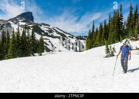 Aventurier fait son chemin sur Panorama Ridge avec l'emblématique Black Tusk au loin Banque D'Images