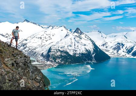 Un randonneur solitaire observe la splendeur glacée de Garibaldi depuis Panorama Ridge Banque D'Images