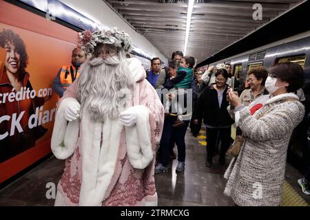 Mexico, Mexique. 20 décembre 2023. L'artiste scénique spécialisé dans le statuisme, Jose Miguel Moctezuma, caractérisé comme le Père Noël illuminé, distribue des câlins et prend une photo souvenir avec les utilisateurs du système de transport collectif Metro à Mexico. Le 20 décembre 2023 à Mexico, Mexique (crédit image : © Luis Barron/eyepix via ZUMA Press Wire) USAGE ÉDITORIAL SEULEMENT! Non destiné à UN USAGE commercial ! Banque D'Images