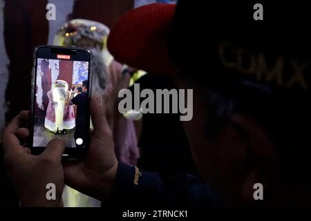 Mexico, Mexique. 20 décembre 2023. L'artiste scénique spécialisé dans le statuisme, Jose Miguel Moctezuma, caractérisé comme le Père Noël illuminé, distribue des câlins et prend une photo souvenir avec les utilisateurs du système de transport collectif Metro à Mexico. Le 20 décembre 2023 à Mexico, Mexique (crédit image : © Luis Barron/eyepix via ZUMA Press Wire) USAGE ÉDITORIAL SEULEMENT! Non destiné à UN USAGE commercial ! Banque D'Images