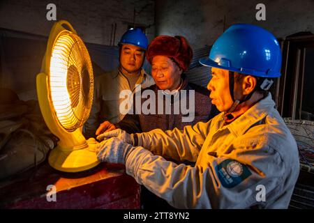 TAIZHOU, CHINE - 19 DÉCEMBRE 2023 - les travailleurs du service de grille enseignent aux personnes âgées comment utiliser en toute sécurité les appareils de chauffage à Taizhou, province du Jiangsu, Chine, Banque D'Images