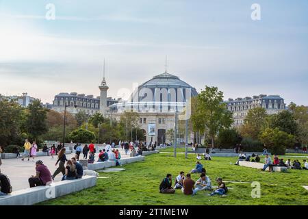 Les gens se détendent dans les jardins devant le bâtiment de la Bourse de Commerce, Paris, France. Banque D'Images