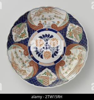 Plat avec hoo-oiseaux et plantes à fleurs dans des panneaux sur le modèle de couche, anonyme, c. 1700 - c. 1724 soucoupe en porcelaine avec bord lobé, peint en bleu glacé sous-jacent et sur le bleu glacé, rouge, vert, turquoise, noir et or. Sur le plat un médaillon avec trois branches de fleurs stylisées ; au médaillon un servetwork de pneus entrecoupé d'un rang. Le mur et le bord avec servetwork sur un fond de bleu glacé sous-jacent. Il variait alternativement trois grosses cartouches avec un oiseau Hoo volant sur des plantes à fleurs et trois cartouches festonnées avec des plantes à fleurs. Quatre fois les objets de valeur (pierre musicale, Banque D'Images