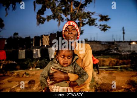 Nairobi, Kenya. 19 décembre 2023. Une colporteuse porte son petit-enfant dans le bidonville de kibera, Nairobi. Une vue à travers la vie quotidienne à Kibera est actuellement Africaís le plus grand bidonville et les activités commerciales quotidiennes effectuées par les résidents locaux. Crédit : SOPA Images Limited/Alamy Live News Banque D'Images