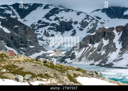 La cabane de montagne surplombe le paisible lac glaciaire Wedgemount entouré de pics escarpés. Banque D'Images