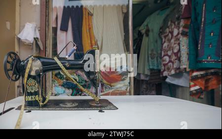 Une vieille machine à coudre sur une table de tailleur. Banque D'Images