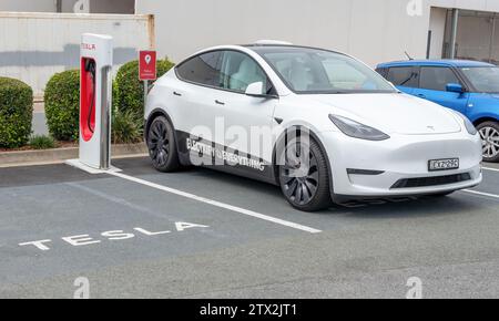 RUNAWAY BAY, QUEENSLAND, AUSTRALIE. 21 décembre 2023, voiture Tesla en charge au centre commercial Runaway Bay, Queensland, Australie. Banque D'Images