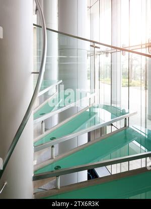 Escalier moderne en colimaçon en verre avec mains courantes métalliques Banque D'Images