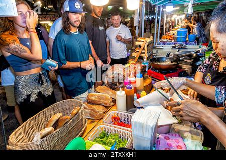 Vendeur de stalle de nourriture et client touristique au marché de nuit, Fishermans Village, Bo Phut, Ko Samui, Thaïlande Banque D'Images