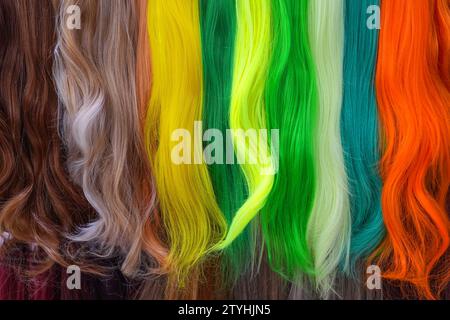 Échantillons de cheveux de palette de couleurs différentes. Différentes couleurs de teinte riche brillante des cheveux - jaune, vert, cramoisi, orange. Diverses couleurs de cheveux définissent l'arrière-plan Banque D'Images