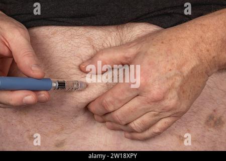 Prise en charge du diabète : injection d'insuline dans le ventre avec Insulin Pen Banque D'Images
