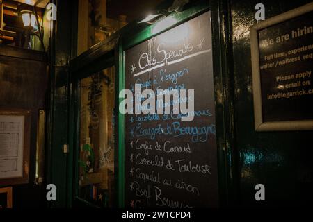 Menu manuscrit de plats frais sur un tableau noir à l'extérieur d'un restaurant londonien dans le West End, en soirée Banque D'Images