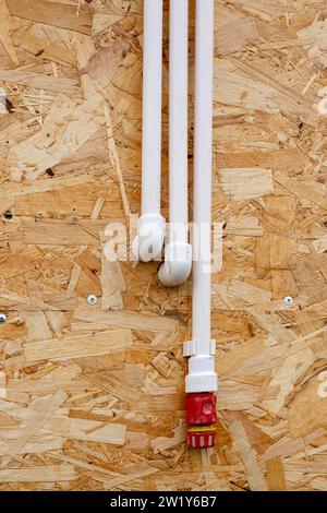 Tuyaux en polypropylène d'alimentation en eau sur une surface murale en bois. Installation de plomberie pour cabine de douche d'été. Banque D'Images