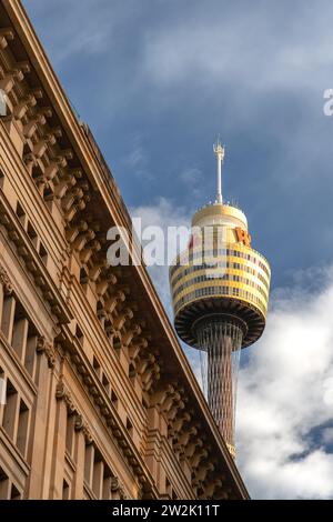 Sydney Eye Tower (anciennement Centrepoint Tower) s'est éclairée par la lumière du soleil contre les nuages de tempête, et a vu sur un bâtiment historique. Banque D'Images