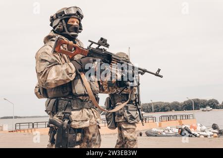 Soldat d'un groupe de forces spéciales debout avec une mitrailleuse lourde. Concept d'opérations spéciales. SWAT. Supports mixtes Banque D'Images