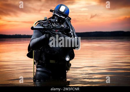 Le marin sort de l'eau et se dirige vers la cible avec les armes à la main. Le concept de jeux vidéo, la publicité, l'instabilité dans le Banque D'Images