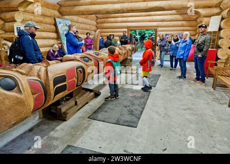 Potlatch Totem, Potlatch Park, Carving Center, visiteurs, familles écoutant le porte-parole autochtone décrivant la construction des totems. Banque D'Images