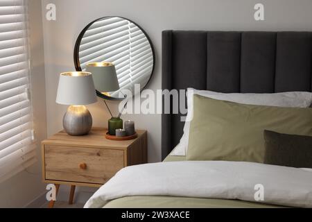 Lampe et bougies sur la table de chevet près du lit dans la chambre Banque D'Images
