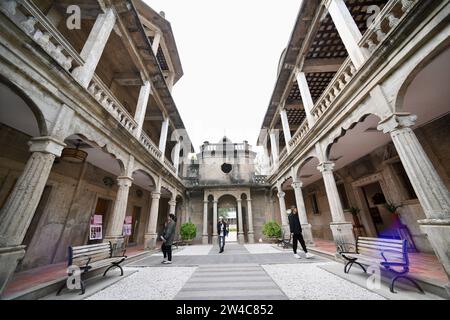JINJIANG, 21 déc. 2023 (Xinhua) -- des touristes visitent un bâtiment historique dans le village de Wulin de Jinjiang, dans la province du Fujian, dans le sud-est de la Chine, le 19 décembre 2023. Dans le village de Wulin, dans la province du Fujian de l'est de la Chine, les visiteurs sont souvent fascinés par le mélange de styles architecturaux : maisons locales en briques rouges, bâtiments gothiques, structures gréco-romanes et bâtiments mêlant éléments chinois et occidentaux. Le mélange éclectique de styles architecturaux raconte de façon vivante l'histoire de la connexion du village avec la communauté chinoise d'outre-mer. À la fin du 19e et au début du 20e siècle, beaucoup vi Banque D'Images