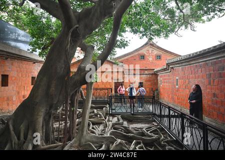 JINJIANG, 21 déc. 2023 (Xinhua) -- des touristes visitent un bâtiment Minnan en briques rouges dans le village de Wulin de Jinjiang, dans la province du Fujian, dans le sud-est de la Chine, le 19 décembre 2023. Dans le village de Wulin, dans la province du Fujian de l'est de la Chine, les visiteurs sont souvent fascinés par le mélange de styles architecturaux : maisons locales en briques rouges, bâtiments gothiques, structures gréco-romanes et bâtiments mêlant éléments chinois et occidentaux. Le mélange éclectique de styles architecturaux raconte de façon vivante l'histoire de la connexion du village avec la communauté chinoise d'outre-mer. À la fin du 19e et au début du 20e siècle, m Banque D'Images