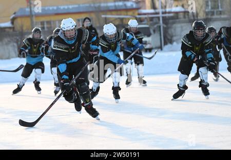 (231221) -- URUMQI, 21 déc. 2023 (Xinhua) -- des élèves de l'équipe de hockey sur glace participent à un entraînement au collège Shuixigou dans le comté d'Urumqi, dans la région autonome ouygur du Xinjiang, au nord-ouest de la Chine, le 20 décembre 2023. Le collège de Shuixigou, une école d’éducation de neuf ans dans le comté d’Urumqi au Xinjiang, a développé son éducation aux sports d’hiver depuis plus de 20 ans. Les élèves reçoivent des cours élémentaires de patinage sur glace à leurs classes inférieures, après quoi ils peuvent choisir de participer à l'équipe de patinage de vitesse, à l'équipe de hockey sur glace ou à l'équipe de patinage artistique en fonction de leurs circonstances individuelles. Années de e Banque D'Images