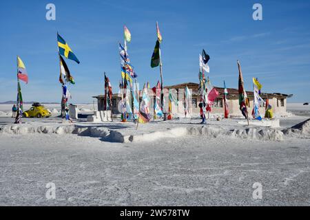 Drapeaux internationaux à l'extérieur de l'hôtel Salt près du monument Dakar Bolivie à Salar de Uyuni, près de Colchan. Uyuni Salt Flat, Bolivie. Banque D'Images