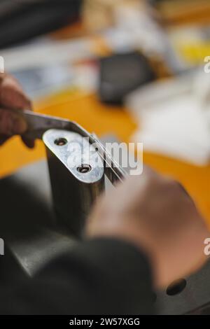 Méconnaissable luthier luthier artisan mains dans son atelier exécutant le processus de bandes de ronfling de contrôleur de courbure dans l'outil de fer pour un nouveau dos brut et Banque D'Images