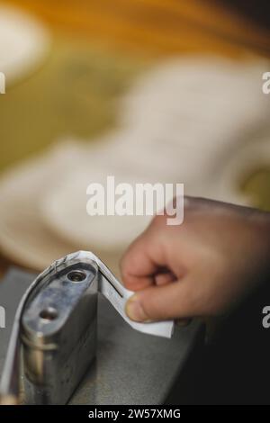 Luthier fabricant de luth méconnaissable artisan à deux mains exécutant le processus de bandes de ronflage de contrôleur de courbure dans l'outil de fer pour un nouveau dos et avant brut Banque D'Images