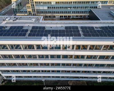 PRODUCTION - 16 décembre 2023, Saxe, Leipzig : installation d'un système solaire sur le toit d'une école à Leipzig. Le nombre de systèmes photovoltaïques installés sur les toits municipaux en Saxe est en augmentation. À la fin de 2023, Leipzig aura produit plus de 1 000 mégawattheures d'électricité par an à partir de panneaux photovoltaïques sur les toits municipaux. D'ici la fin de 2023, un total de 23 écoles de Leipzig, une salle de sport, une caserne de pompiers et une garderie dans la ville d'exposition auront de tels systèmes. (Vue aérienne avec drone) photo : Jan Woitas/dpa Banque D'Images