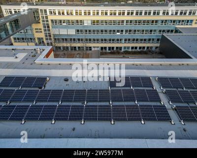 PRODUCTION - 16 décembre 2023, Saxe, Leipzig : installation d'un système solaire sur le toit d'une école à Leipzig. Le nombre de systèmes photovoltaïques installés sur les toits municipaux en Saxe est en augmentation. À la fin de 2023, Leipzig aura produit plus de 1 000 mégawattheures d'électricité par an à partir de panneaux photovoltaïques sur les toits municipaux. D'ici la fin de 2023, un total de 23 écoles de Leipzig, une salle de sport, une caserne de pompiers et une garderie dans la ville d'exposition auront de tels systèmes. (Vue aérienne avec drone) photo : Jan Woitas/dpa Banque D'Images