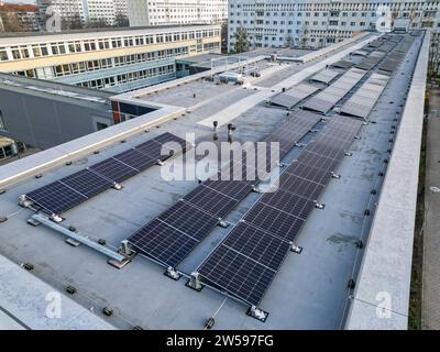 PRODUCTION - 16 décembre 2023, Saxe, Leipzig : installation d'un système solaire sur le toit d'une école à Leipzig. Le nombre de systèmes photovoltaïques installés sur les toits municipaux en Saxe est en augmentation. À la fin de 2023, Leipzig aura produit plus de 1 000 mégawattheures d'électricité par an à partir de panneaux photovoltaïques sur les toits municipaux. D'ici la fin de 2023, un total de 23 écoles de Leipzig, une salle de sport, une caserne de pompiers et une garderie dans la ville d'exposition auront de tels systèmes. (Vue aérienne avec drone) photo : Jan Woitas/dpa Banque D'Images